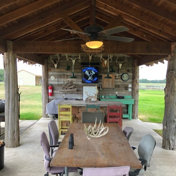 party pavilion with dining, fireplace, and firepit at oak creek ranch hunting lodge in columbus, tx